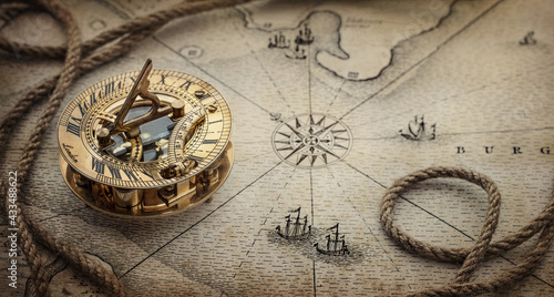Magnetic old compass  and rope on vintage world map. Travel, geography, navigation, tourism and exploration concept wide background. Macro photo. Very shallow focus.