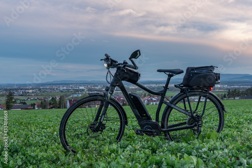 Black and gray electric bicycle in sunset time with cloudy sky