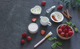 Ingredients homemade strawberry face mask, cream, strawberry, oatmeal, spices, herbs on a dark background, top view, copy space, flat lay/ Home hand-made cosmetics made from natural ingredient
