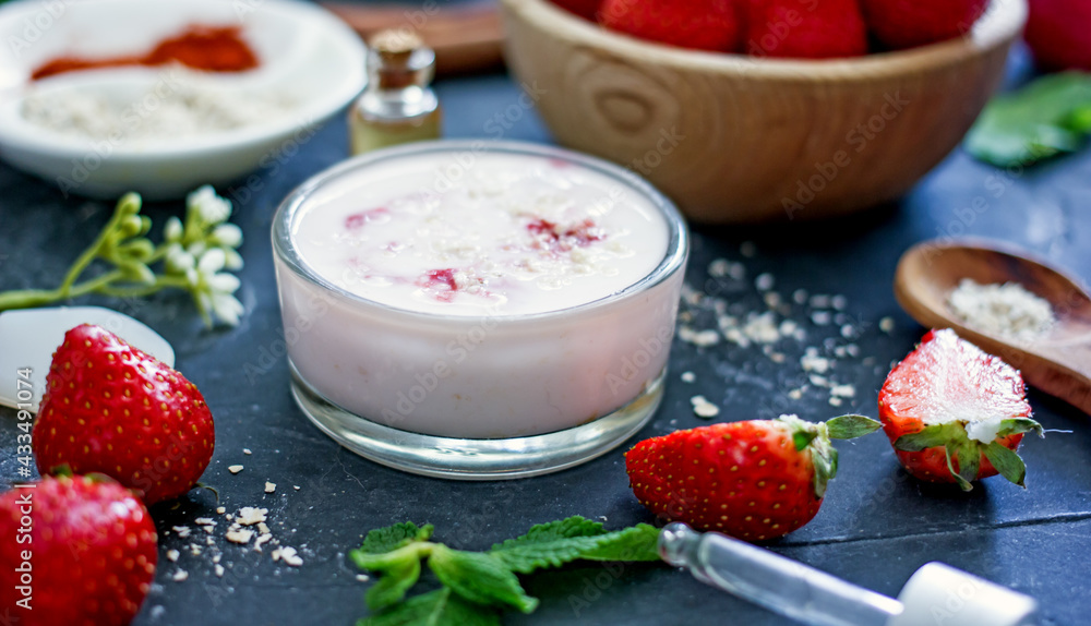 Homemade strawberry face mask with oatmeal and cream on a dark background. Concept of natural handmade cosmetics Homemade strawberry face mask with oatmeal and cream on a dark background. Concept of natural handmade cosmetics