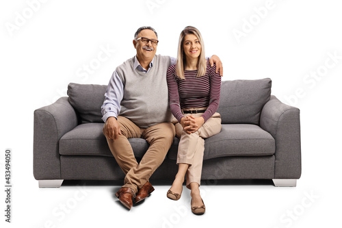 Father and daughter seated on a sofa in embrace
