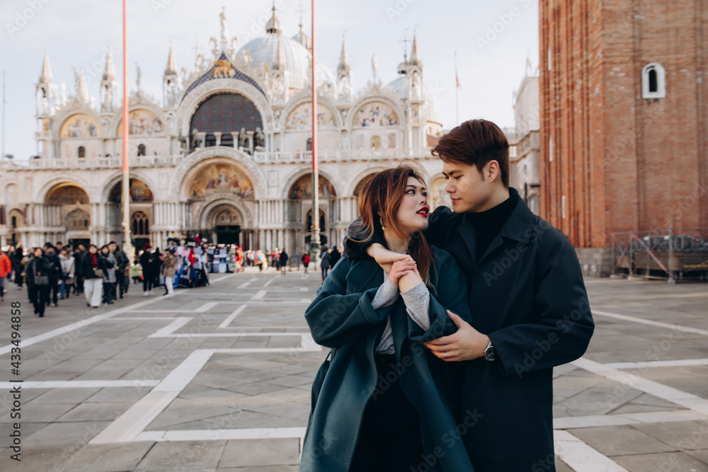Fototapeta premium A love story in a town square with a boyfriend and girlfriend. Young people travel to Europe.