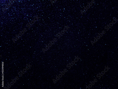Dark blue starry night sky galaxy background.  Blue shining glitter background. 