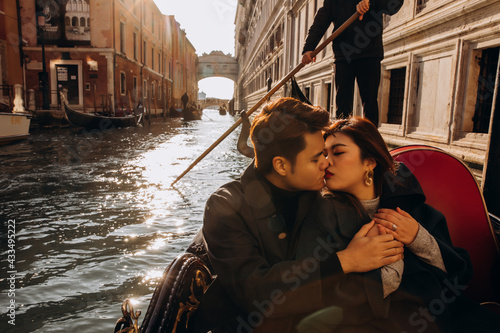 A romantic ride for a guy and a girl on a gondola through the canals of Venice. A young couple travels to Italy. © dimadasha