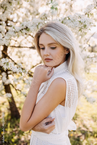 Portrait of a young woman with long blonde hair outdoors  in a park.