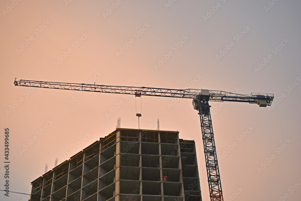 Unfinished house and tower crane in the evening Unfinished house and tower crane in the evening