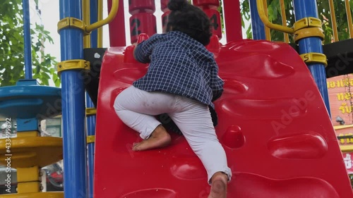Happy asian kid adorable are playing at the playground, kids having fun playing with climbing the wall, activities kids, enjoy and leaning outdoor of kids concept, in summer time.