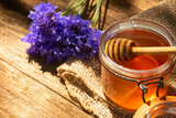 a jar of honey and honey dipper