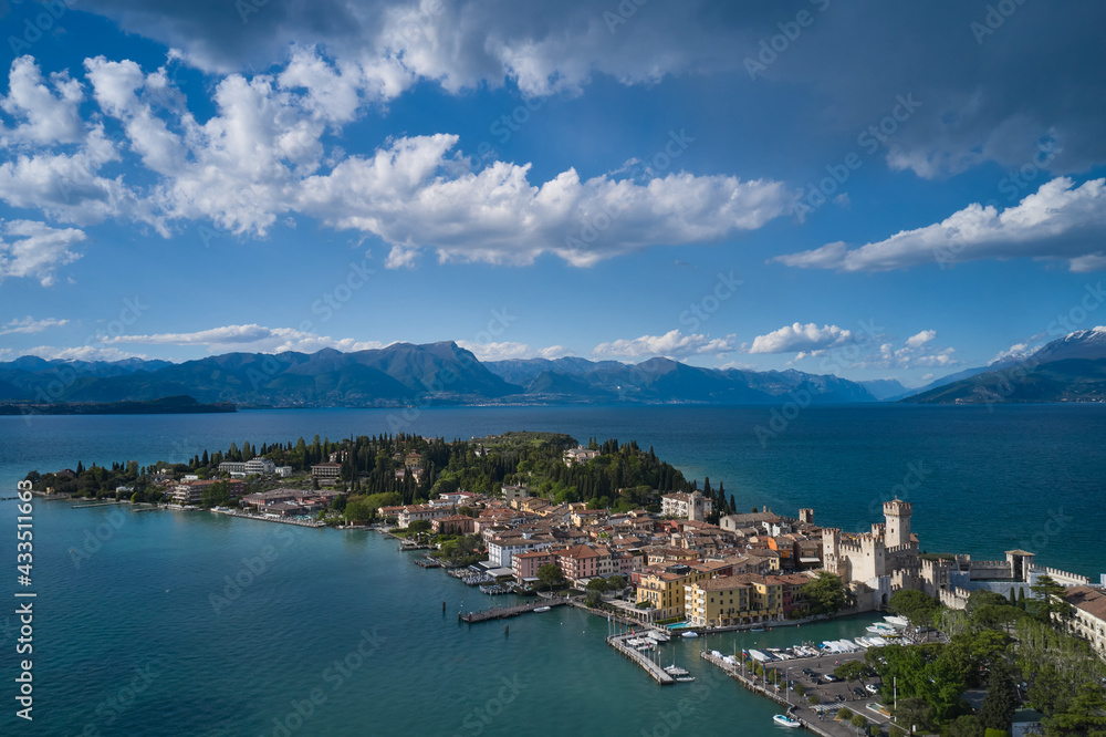 Sirmione, Lake Garda, Italy. Panorama of Lake Garda. Castle on the water in Italy. Peninsula on a mountain lake in the background of the alps. Aerial view of the island of Sirmione.