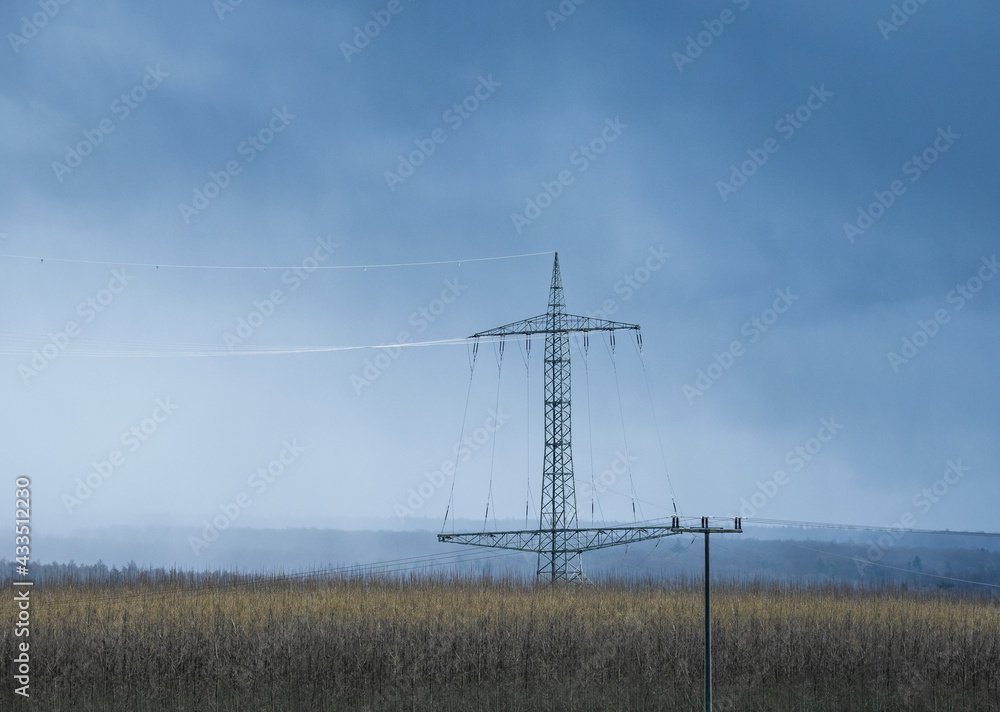 transmission tower  against sky and forest in Germany