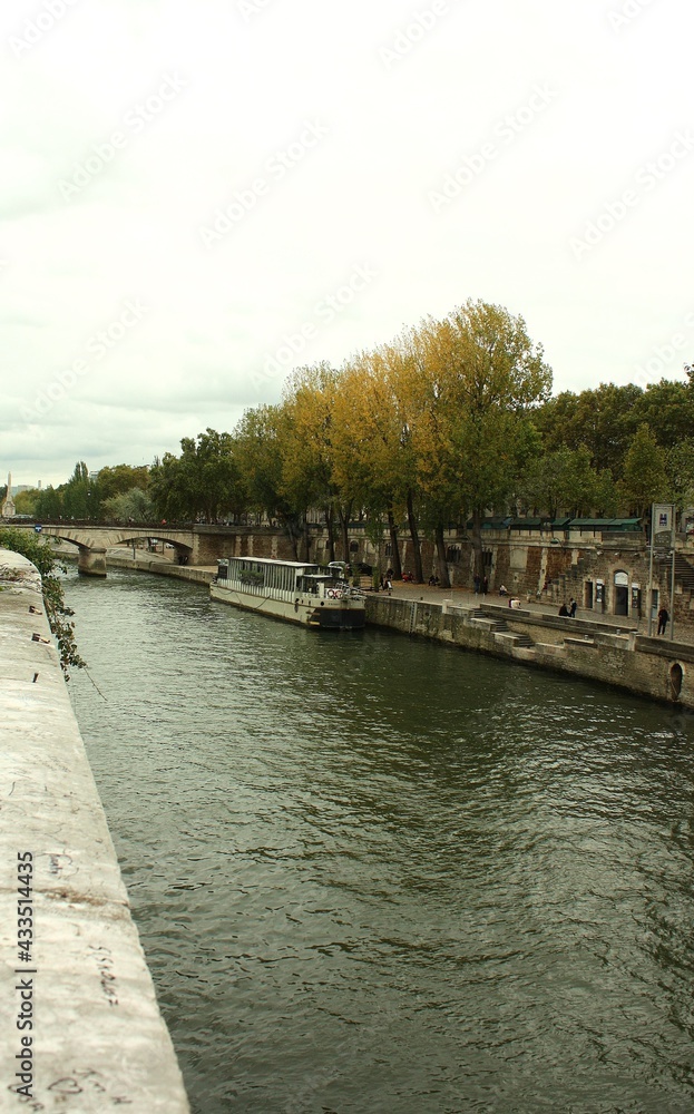 seine river in autumn with boats and a bridge in the background