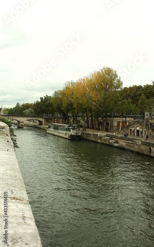 seine river in autumn with boats and a bridge in the background © LPGmoments