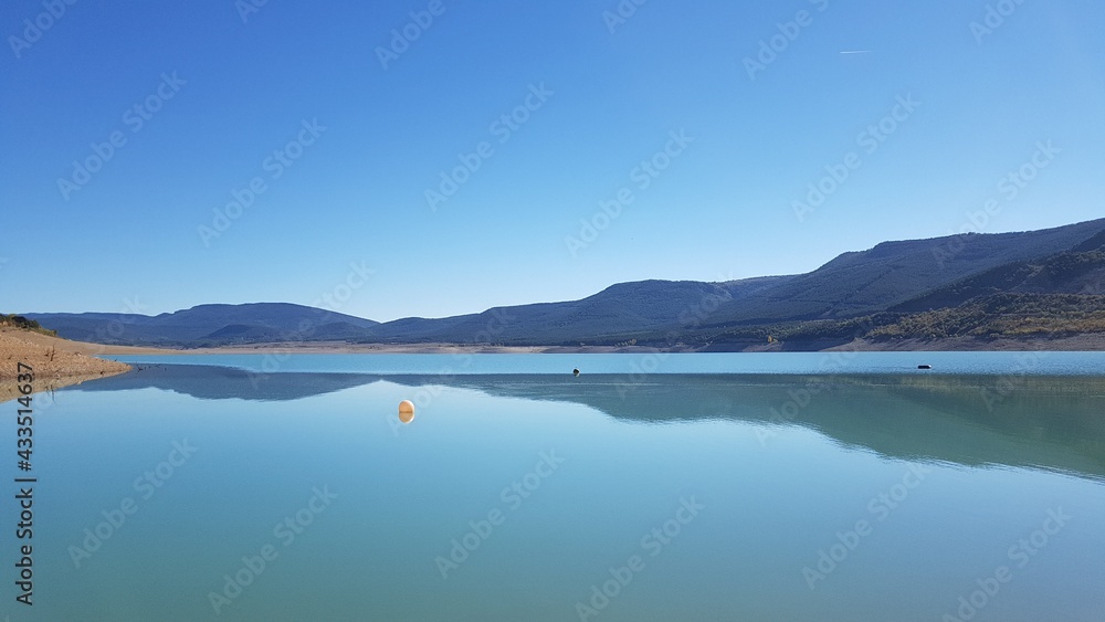 un bonito y tranquilo lago de montañas con agua azul limpia y cielo azul en España
