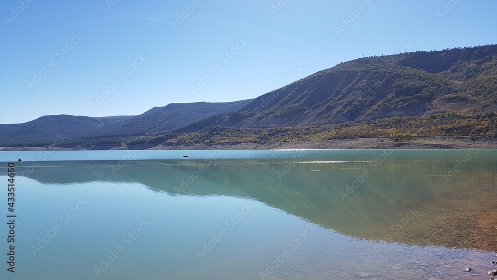 un bonito y tranquilo lago de montañas con agua azul limpia y cielo azul en España