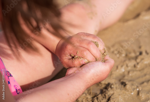 Manos de niña jugando con arena © ANTXON