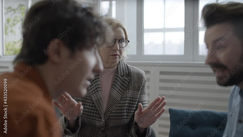 Two men having fight at therapy session, psychologist trying to resolve conflict Two men having fight at therapy session, psychologist trying to resolve conflict