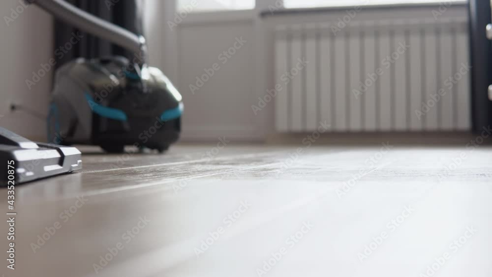 Vacuuming the light oak floor with water. Wet cleaning of housing. Technologies that facilitate cleaning. Modern household appliances Vacuuming the light oak floor with water. Wet cleaning of housing. Technologies that facilitate cleaning. Modern household appliances