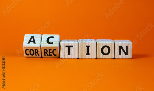 Action or correction symbol. Turned wooden cubes and changed the word correction to action. Beautiful orange background, copy space. Business and action or correction concept. photo