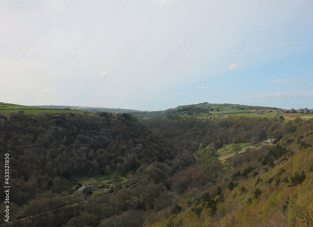 Fototapeta premium view along the colden valley in calderdale near hebden bridge with the village of colden on the hills above the woodland