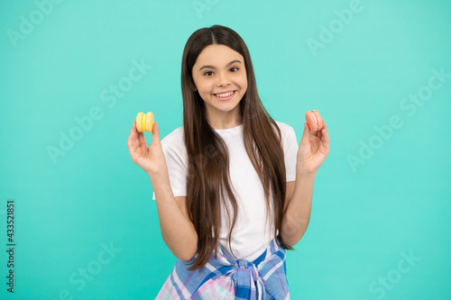 happy teen girl hold french macaron or macaroon cookies, confectionary
