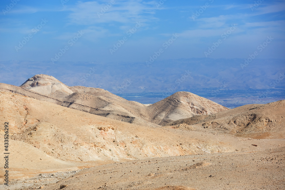 Judean Desert in clear weather, Israel. White sand dunes and blue sky. Wadi Qelt land. Stony desert in the heat