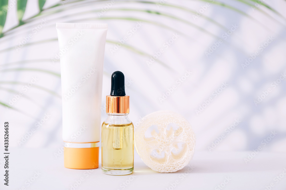 Serum or essential oil bottle and cream tube on light background. Natural organic cosmetic Serum or essential oil bottle and cream tube on light background. Natural organic cosmetic