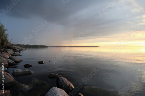 Beautiful sunset on a calm lake with a rocky shore