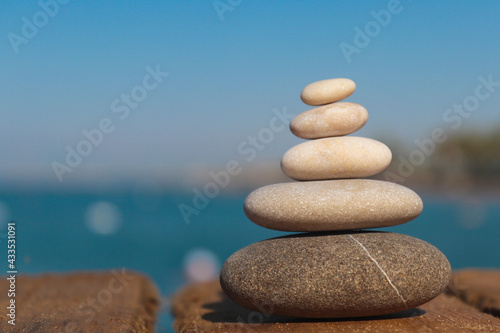 Pyramid of stones by the sea with copy space. Zen concept. Blurred background. Concept of harmony  stability  life balance  and meditation. Summer mood