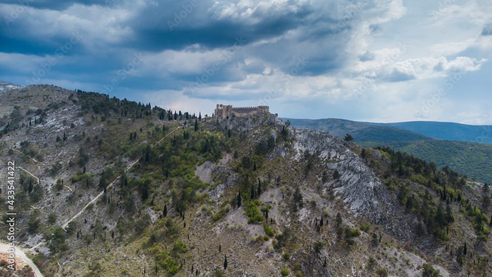 Aerial drone view of fortress fortress on a cliff on cloudy day. Old castle on the hill, view from above. Historic town Blagaj in Bosnia and Herzegovina. Stjepan-grad.  