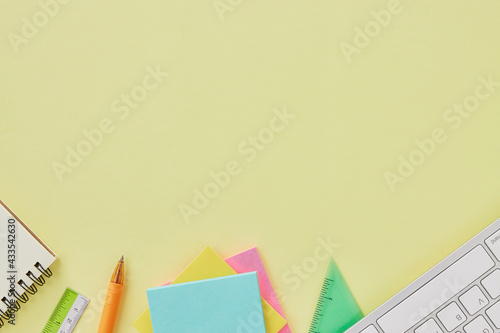Top View or Flat Lay Modern Office Table or Office Desk with Stationery as Keyboard,Ruler,Stick Note,Pen,Notebook. Yellow Minimalist Workspace Background