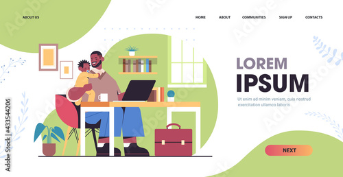 father using laptop and holding little son fatherhood parenting concept dad spending time with kid