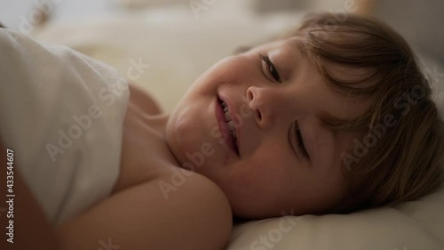 Wallpaper Mural Beautiful baby toddler smiling under bed sheets in the morning Torontodigital.ca