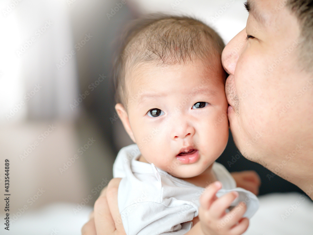close up an Asian father kiss his baby 's face , happy family father 's day close up an Asian father kiss his baby 's face , happy family father 's day