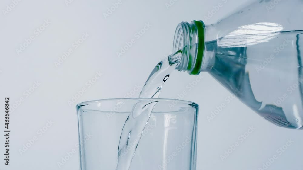Close up slow motion pouring drink water into drinking glass Close up slow motion pouring drink water into drinking glass