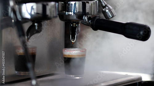 Close up photo of making coffee with machine in cafe. Professional modern espresso coffee machine pours hot drink into the cup. Concept coffee in cafe.