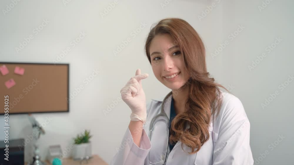 Smiling young woman doctor cardiologist wearing white medical coat and stethoscope showing hands heart shape looking at camera. Cardiology healthcare, love and medicine charity concept, portrait. Smiling young woman doctor cardiologist wearing white medical coat and stethoscope showing hands heart shape looking at camera. Cardiology healthcare, love and medicine charity concept, portrait.