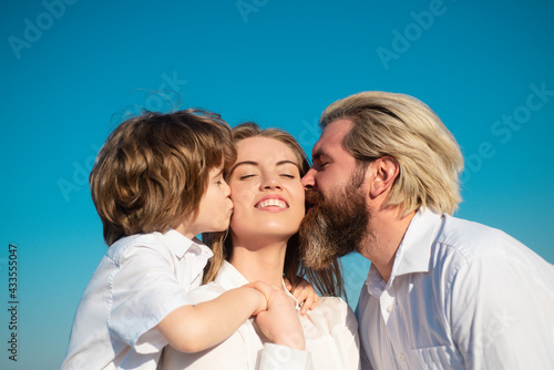 Parenting. Happy family. Motherhood fatherhood. Son and dad kiss mother. Young family with child. Kids love. Mothers day.