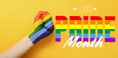 Female hand with painted rainbow and text LGBT PRIDE MONTH on color background