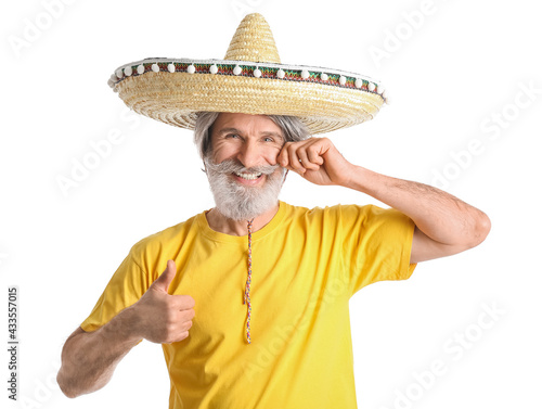 Senior man in sombrero hat showing thumb-up on white background