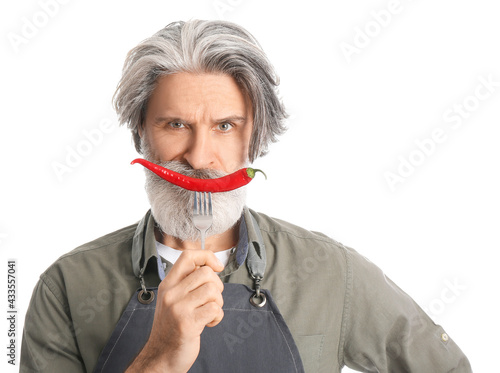 Senior man with chili peppe...