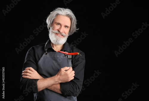 Senior man with chili peppe...