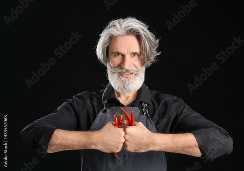 Senior man with chili peppe...
