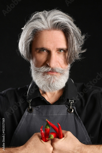 Senior man with chili peppe...