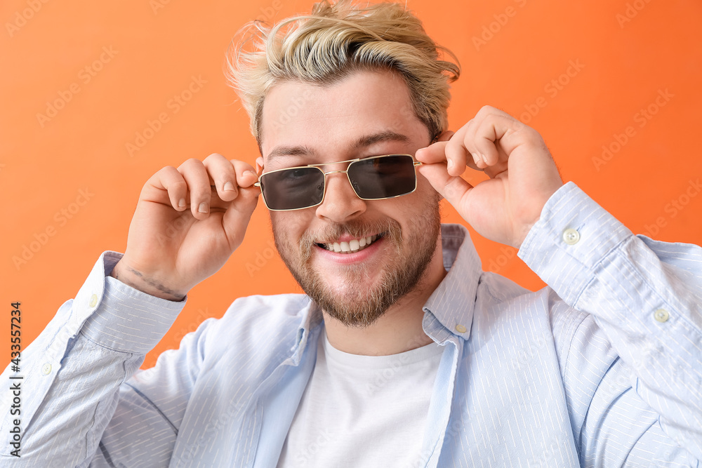 Young man with stylish sunglasses on color background Young man with stylish sunglasses on color background