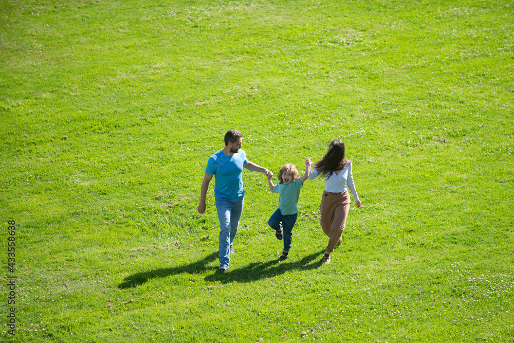 Father mother and son running in the park. Beauty nature scene with family outdoor lifestyle. Father mother and son running in the park. Beauty nature scene with family outdoor lifestyle.