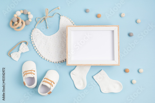 Fotografia Mockup of empty frame with white baby accessories, baby shower, baptism invitati