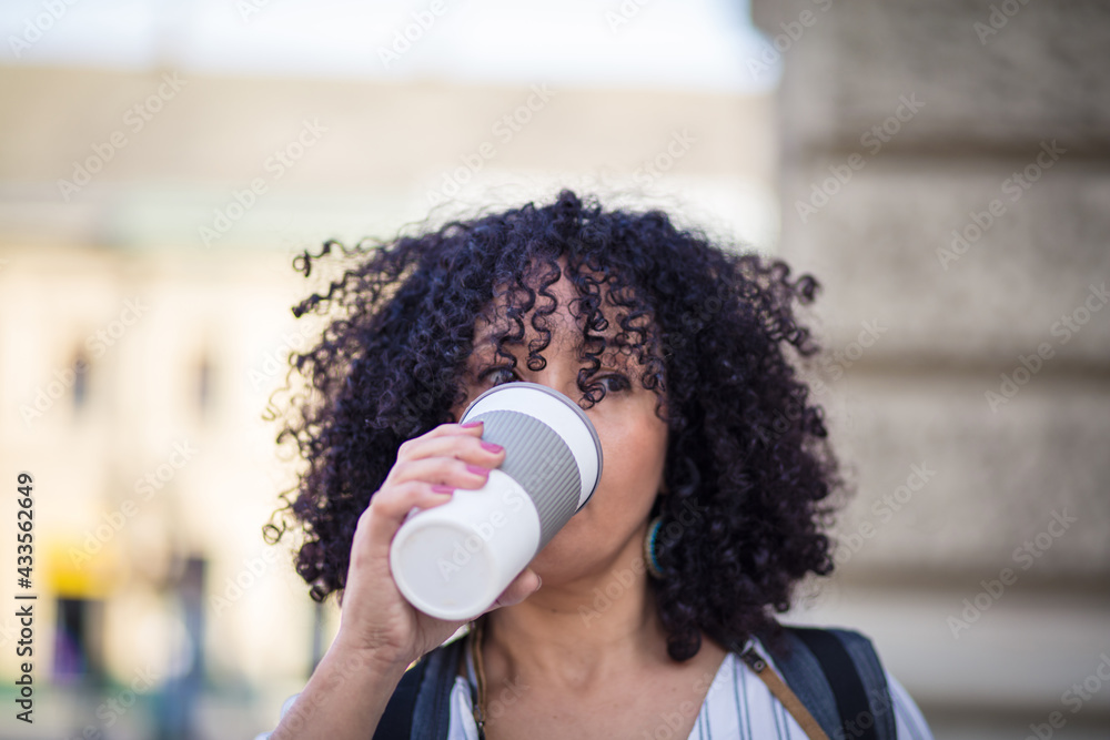 Woman on street drinking coffee. - obrazy, fototapety, plakaty 