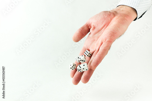 hand throws dice on white background with copy space.