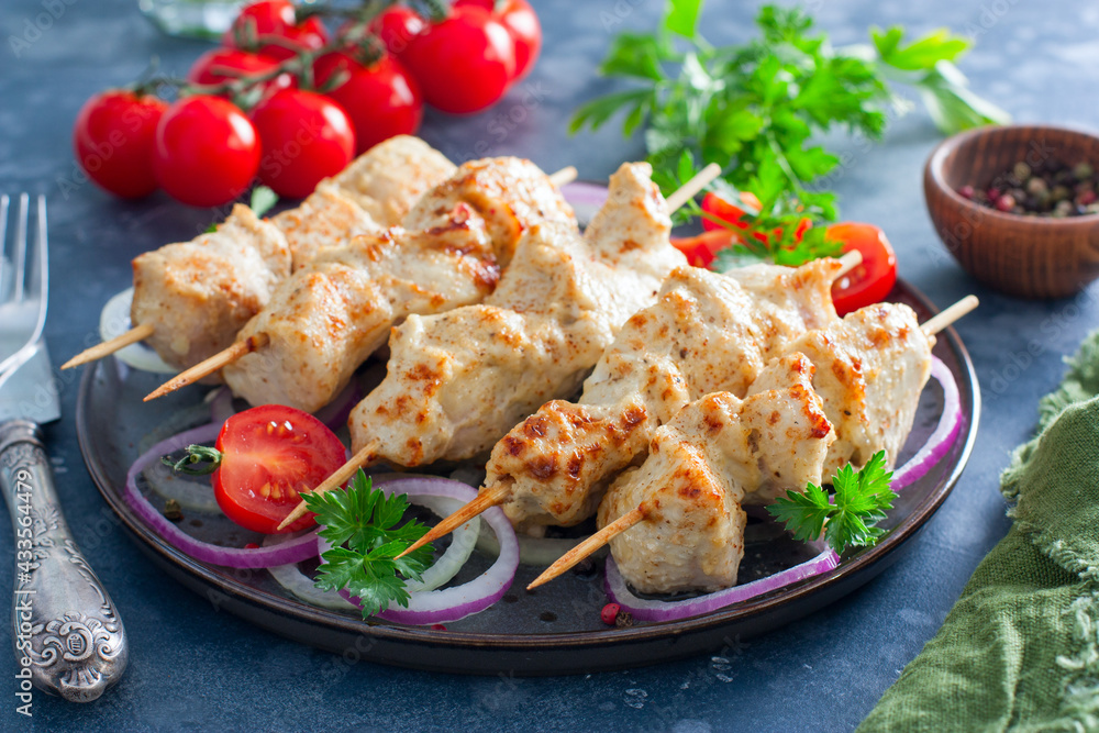 Chicken breast kebab baked in the oven on wooden skewers on a plate, horizontal Chicken breast kebab baked in the oven on wooden skewers on a plate, horizontal