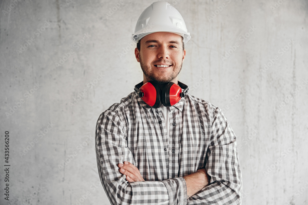 Delighted male builder in hardhat on gray background Delighted male builder in hardhat on gray background